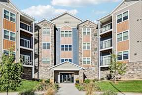 A large apartment complex with a central entrance and a landscaped courtyard.