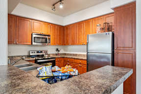 A kitchen with wooden cabinets and a granite countertop.