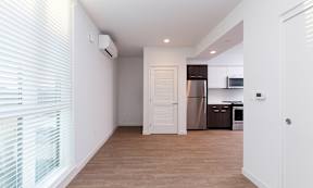 A kitchen area with a refrigerator, microwave, and cabinets.
