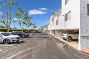 a parking lot in front of a white apartment building