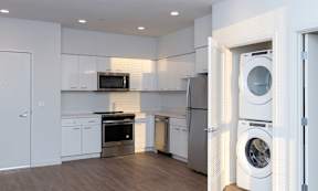 A modern kitchen with white cabinets and appliances.