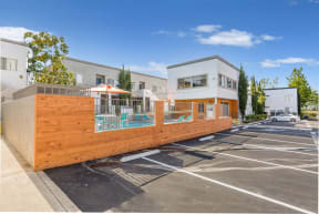 a wooden fence with a pool in the middle of a parking lot