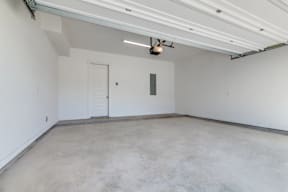 A garage with a white door and a red stripe on the floor.
