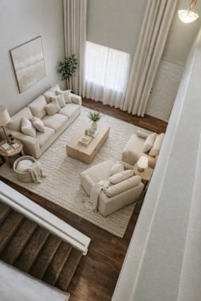 A living room with a white couch and a rug.