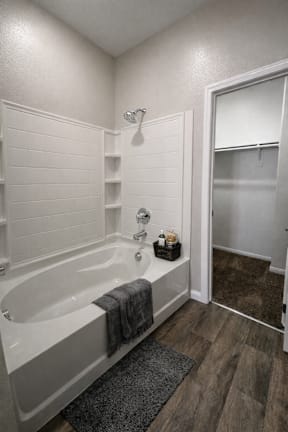 A white bathroom with a tub and a walk in shower.