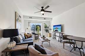 A living room with a couch, chairs, and a television.