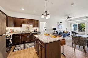 A kitchen with wooden cabinets and a marble countertop.