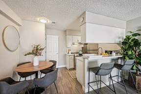 A kitchen with a table and chairs in front of it.