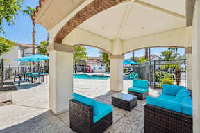A patio with a pool and a blue umbrella.