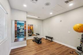 A room with a wooden floor and a wall with a picture of a sunset.