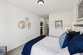 A bedroom with a large bed and a painting on the wall.