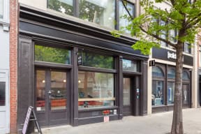 a storefront with a tree in front of it