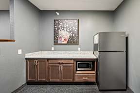 A kitchen with a refrigerator, microwave, and cabinets.