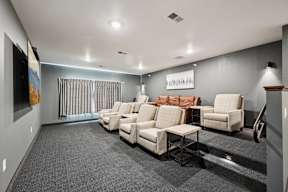 A living room with a grey carpet and white furniture.