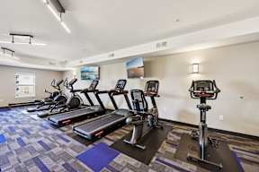 A gym with treadmills and elliptical machines.