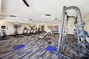 A gym with a variety of equipment including a squat rack.