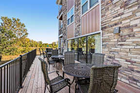 A patio with a table and chairs is on a balcony.