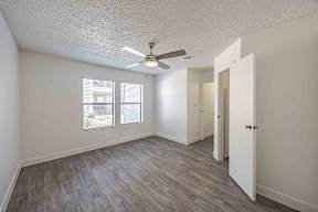 A room with a ceiling fan and a door.