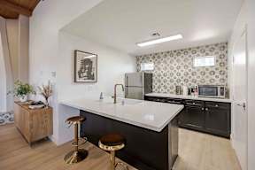 A kitchen with a white countertop and black cabinets.