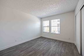 A room with a window and wooden flooring.