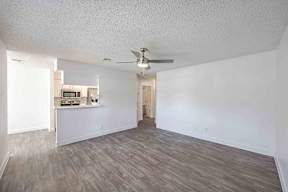 A room with a ceiling fan and a wooden floor.