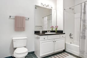 a white bathroom with a toilet and a sink and a shower
