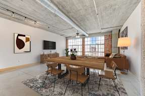 A dining room with a long wooden table and chairs.