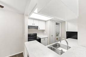 A kitchen with a sink and a stove top oven.