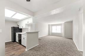 A kitchen with white cabinets and a black refrigerator.