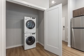 a small laundry room with a washer and dryer in a 555 waverly unit