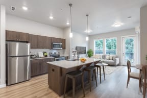 Pet-Friendly Townhomes in Vancouver, WA - The Farmstead - Kitchen with Dark Brown Cabinets, White Countertops, Kitchen Island, and Stainless Steel Appliances.