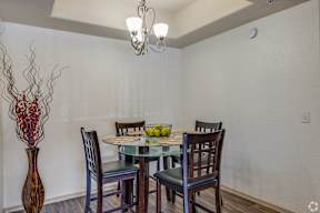 A dining room with a glass table and chairs.