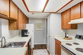 a kitchen with white appliances and wooden cabinets