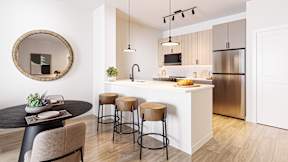 A modern kitchen with a round table and bar stools.