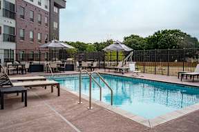 A pool area with a bench and a fence.