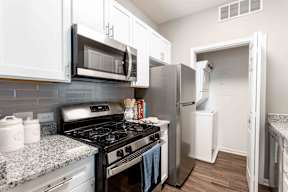 A kitchen with a black stove top oven and a white refrigerator.