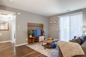 A living room with a couch, a coffee table, and a television.