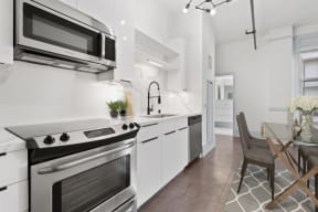 Downtown LA CA Lofts - Santa Fe Lofts - Designer Kitchen with White Cabinets, Marbled Countertops, and Stainless Steel Appliances.