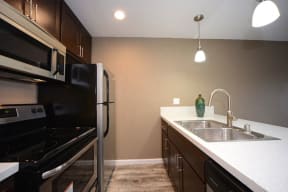 a kitchen with a sink stove refrigerator and microwave