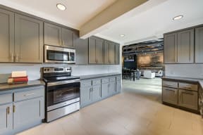 a large kitchen with stainless steel appliances and gray cabinets