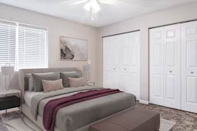 A bedroom with a large bed and a painting on the wall.