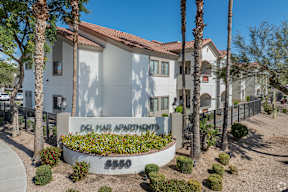 A white building with a red roof and a sign that says Del Mar Apartments.