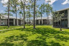 A grassy area in front of apartment buildings.