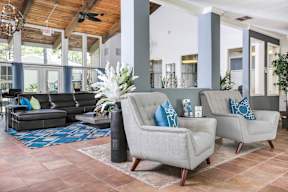 A living room with a black couch and two grey armchairs.