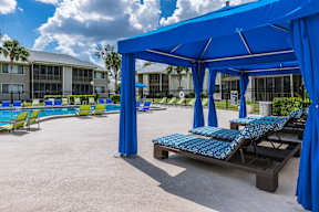 A blue canopy is set up over a table with a blue and white table cloth.