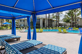 A blue canopy with patterned cushions and umbrellas.