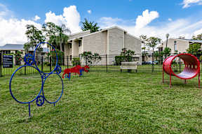A playground with a red slide and a blue monkey bars.