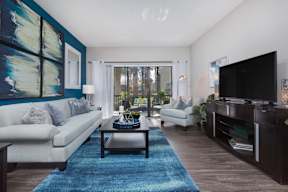 A living room with a white couch, a coffee table, and a flat screen TV.