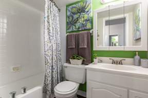 A white toilet sits next to a white sink in a bathroom.