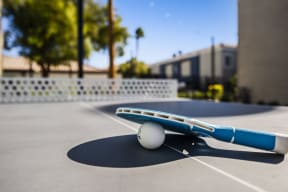 a blue and white airplane sitting on top of a tennis court